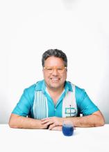 A man smiling in a striped shirt.