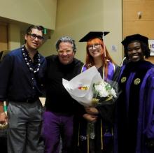 Group of faculty and students come together wearing academic attire at a graduation celebration. 