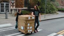 CMS major Allie Smith bringing equipment into Padelford (also pictured: CMS Chair Stephen Groening)