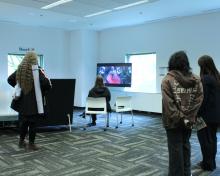 A group watches a film on the TV.