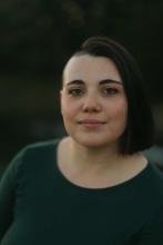 headshot of female wearing green shirt looking into camera