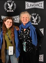 A student and woman pose side-by-side with smiles.