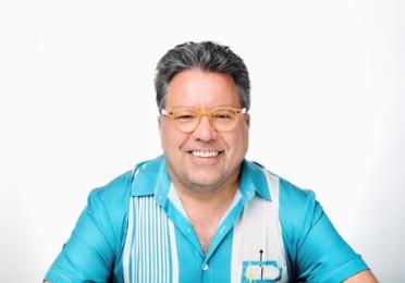 A man smiling in a striped shirt.