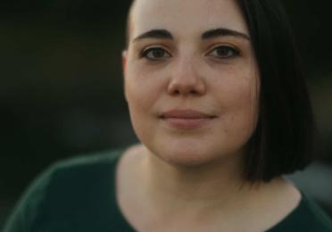 headshot of female wearing green shirt looking into camera
