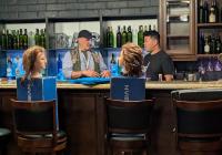 Two male individuals standing behind a bar facing each other