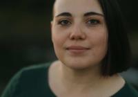 headshot of female wearing green shirt looking into camera