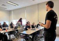 A man, Levi Bond, is speaking to a classroom of students.