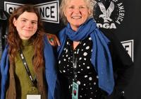 A student and woman pose side-by-side with smiles.