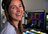 Audrey Spurgeon wearing a headset in a broadcast control room.