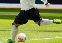 A soccer player kicking a ball. 