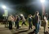 Nighttime crowd under park lamps