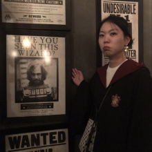 A young woman, gesturing toward Harry Potter themed decor.