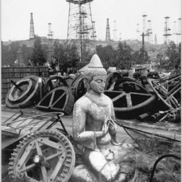 A statue sits among metal cogs.